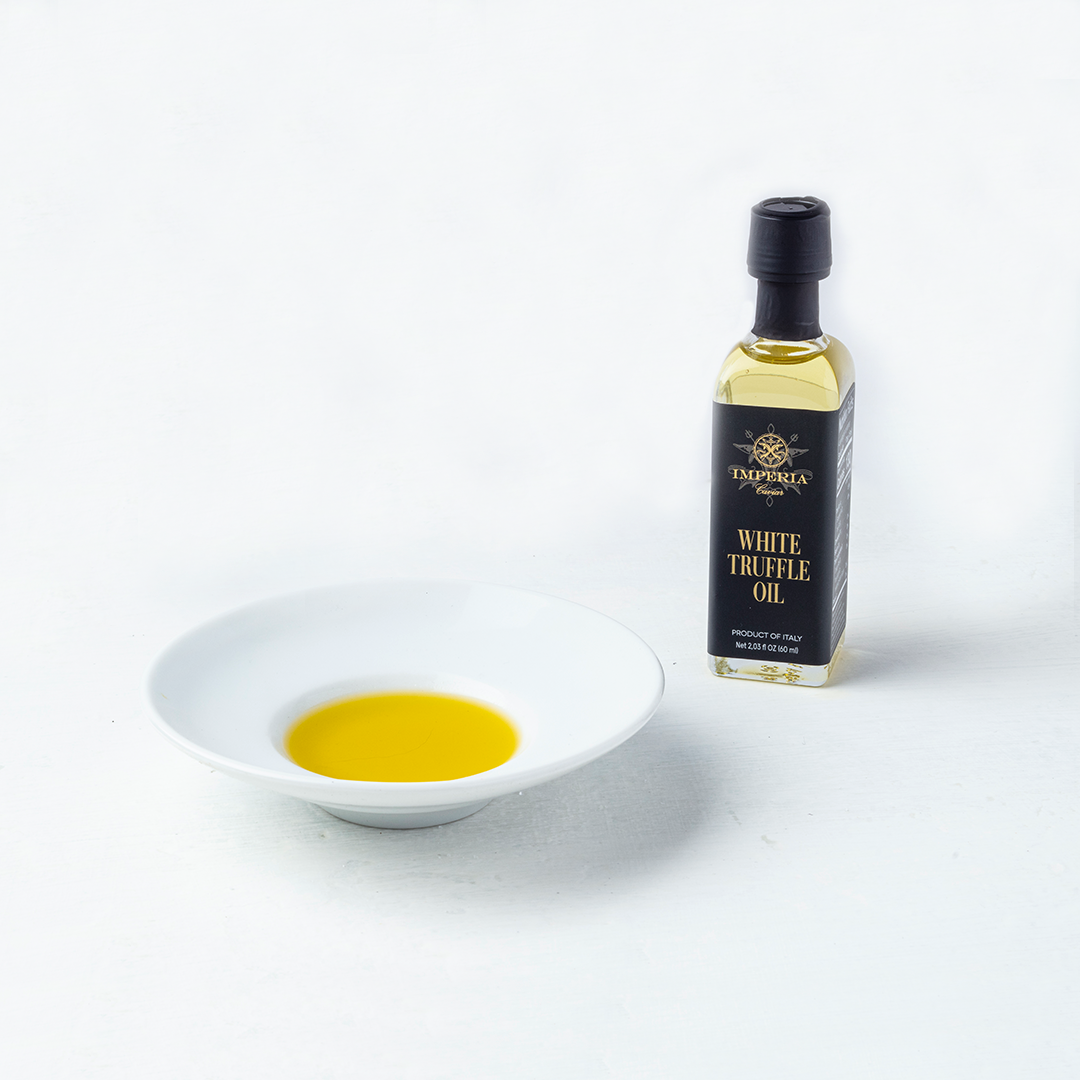 an image showing white truffle oil bottle with a dish of truffle oil